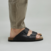Man wearing black bio sandals with a neutral background